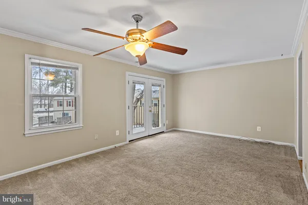 an empty room with windows and fan