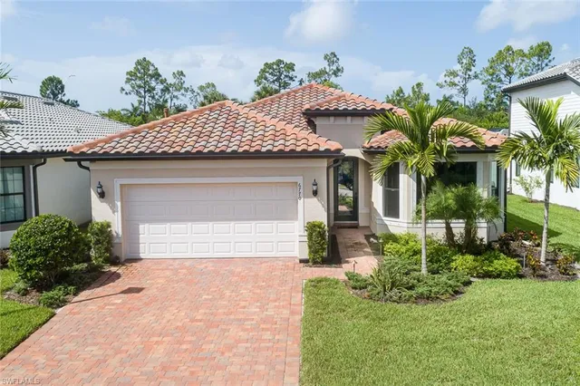 front view of a house with a yard and potted plants