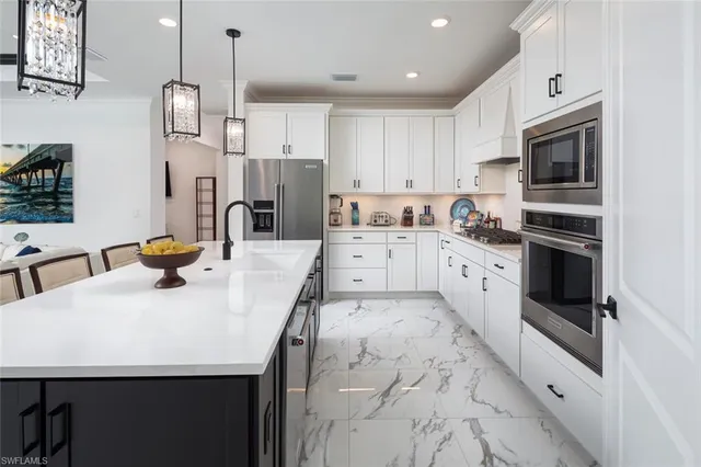 a kitchen with stainless steel appliances kitchen island granite countertop a sink a stove and cabinets
