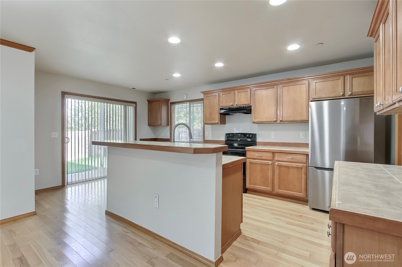 3157 Walker Road DuPont, WA 98327 - Photo 7 of 27 a kitchen with granite countertop a refrigerator and a stove top oven