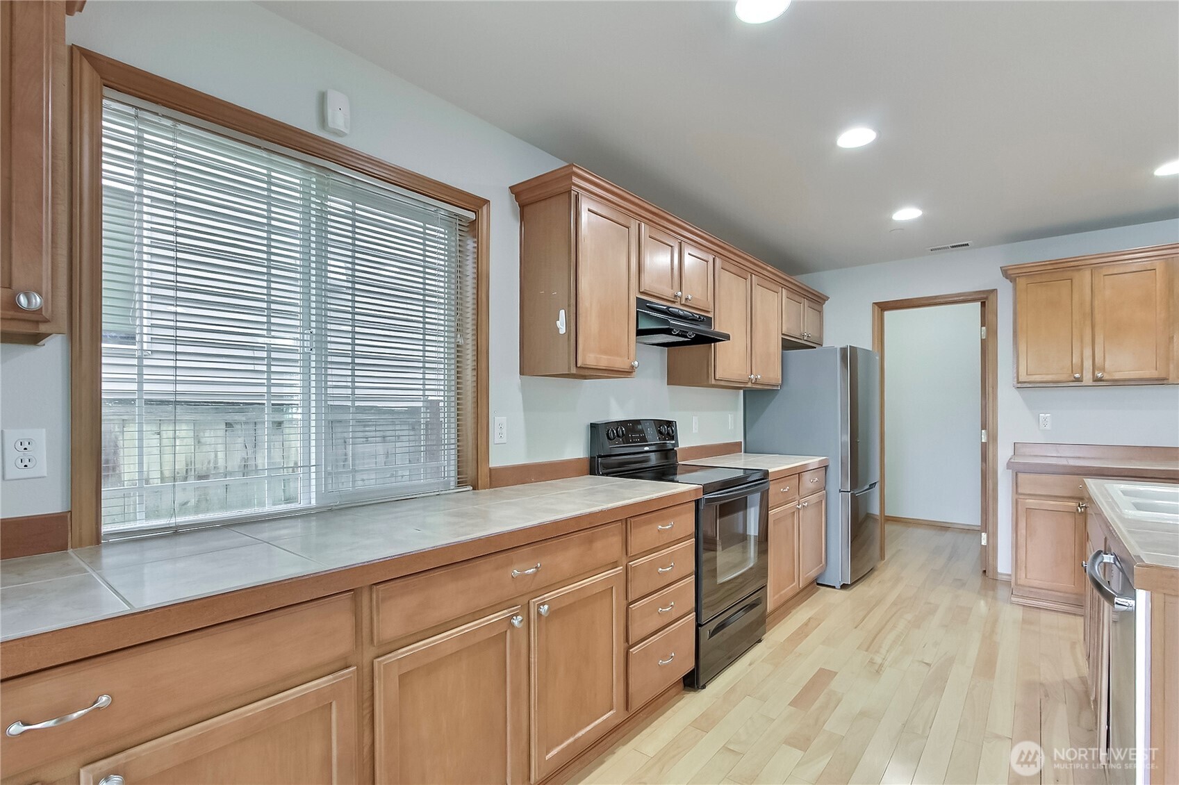 3157 Walker Road DuPont, WA 98327 - Photo 8 of 27 a kitchen with kitchen island granite countertop a sink cabinets stainless steel appliances and a window