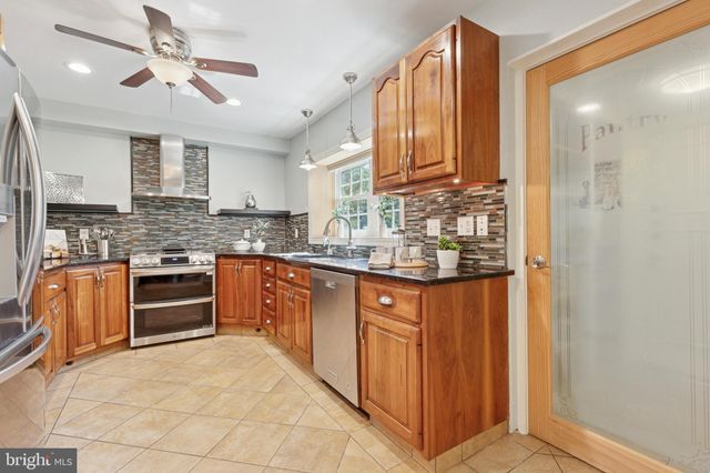 a kitchen with stainless steel appliances granite countertop a stove sink and cabinets