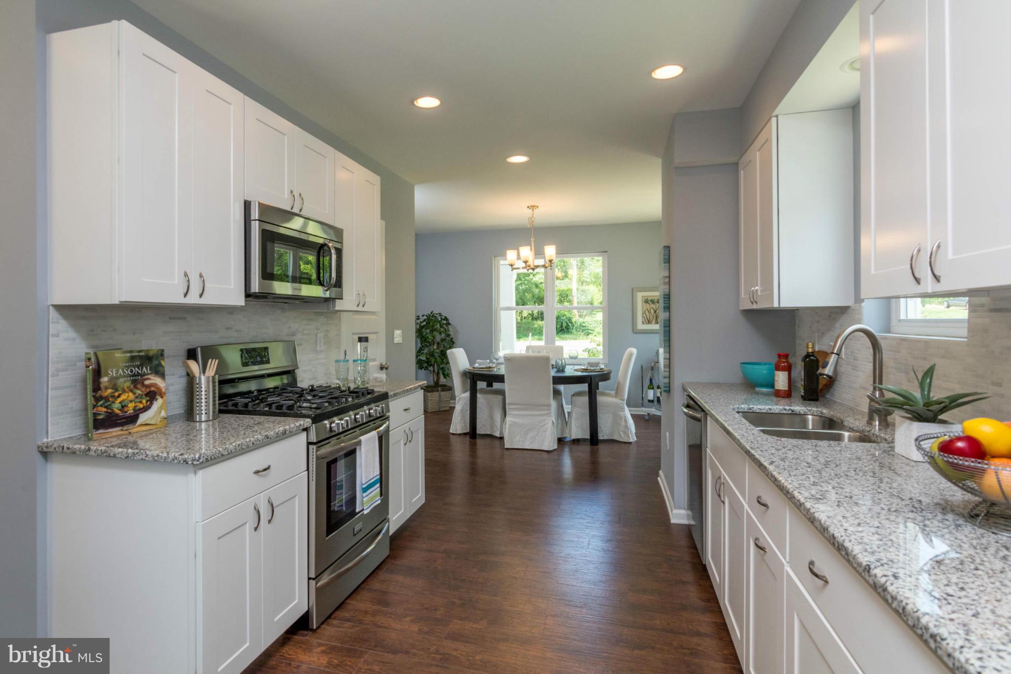 a kitchen with stainless steel appliances granite countertop wooden cabinets a stove top oven a sink and dishwasher