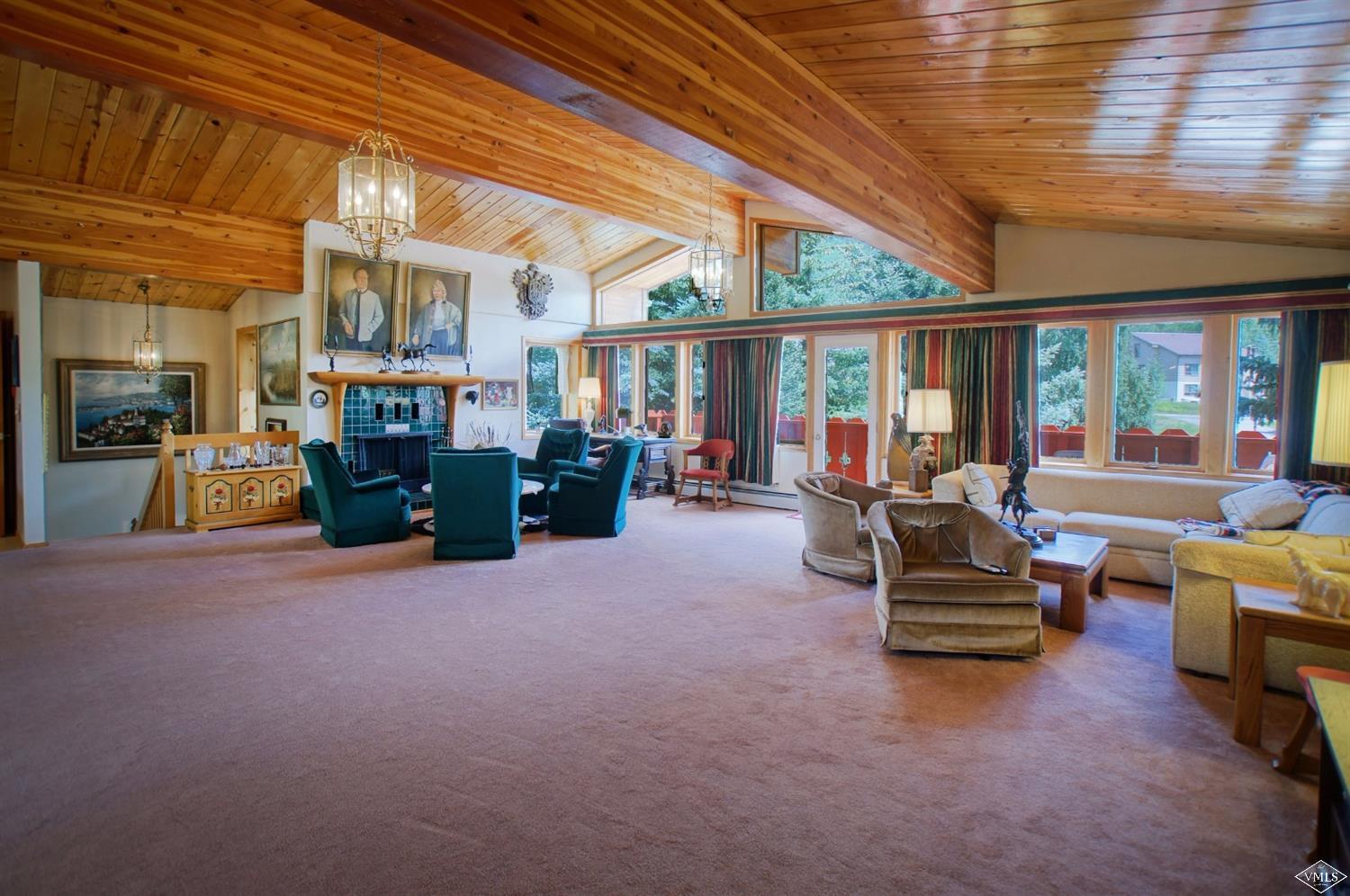 1763 Shasta Place Vail, CO 81657 - Photo 7 of 20 a living room with furniture a fireplace and large windows