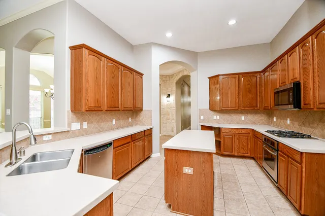 a kitchen with stainless steel appliances a stove microwave and sink