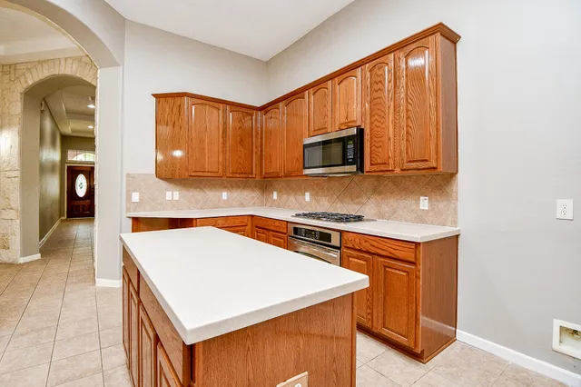 an open kitchen with granite countertop a stove and a sink