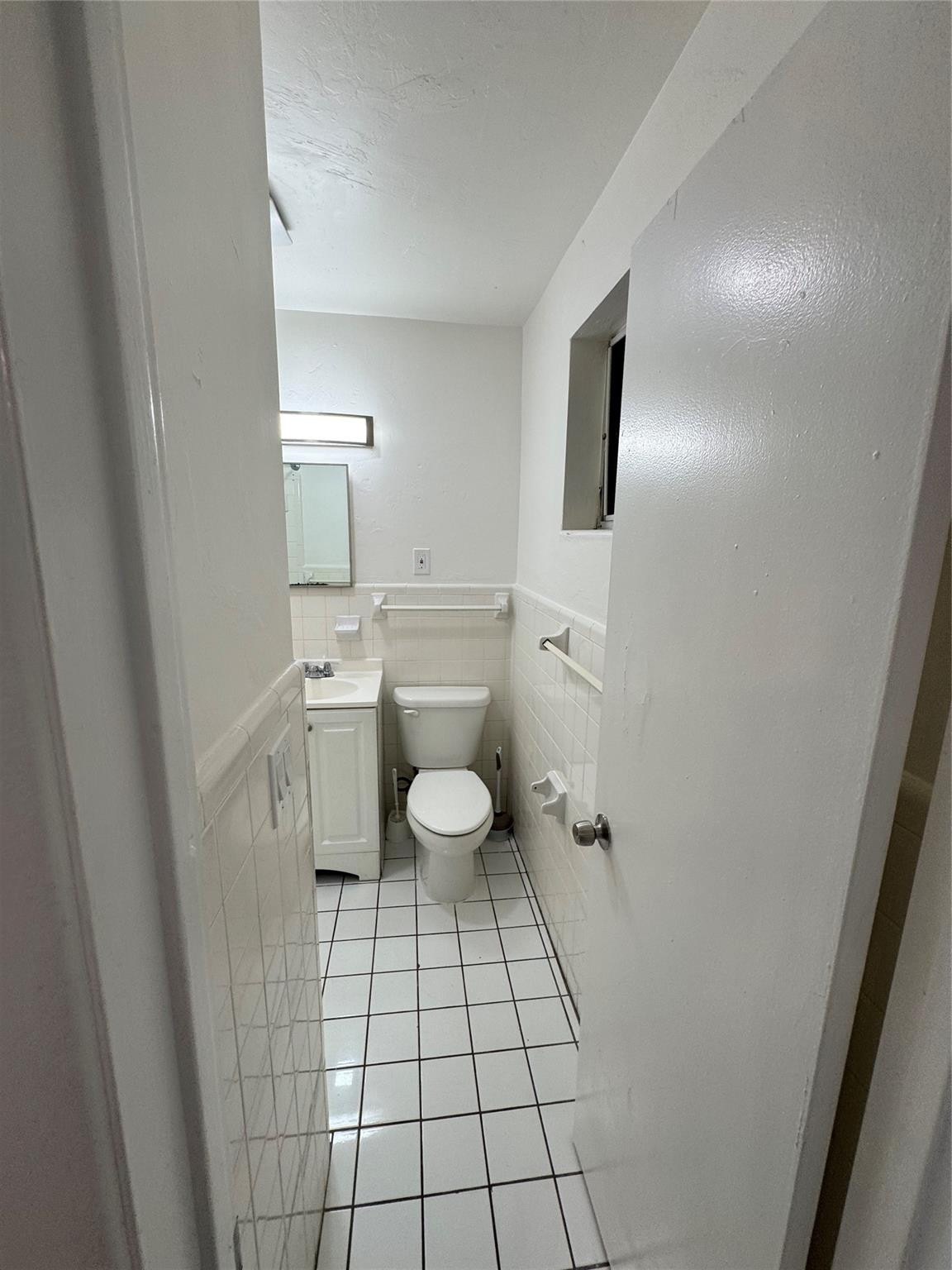 500 Nathan Hale Road, Unit 1 West Palm Beach, FL 33405 - Photo 7 of 8 a bathroom with a sink toilet and mirror