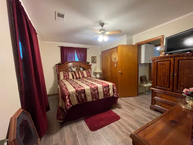 a bedroom with a bed and wooden floor