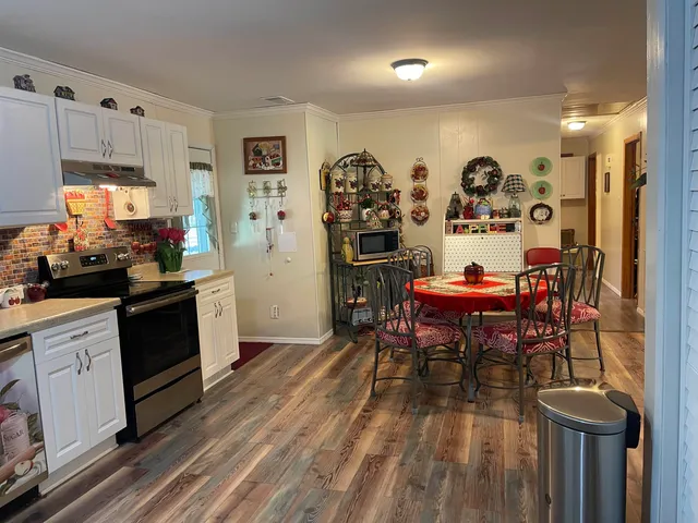 a kitchen with stainless steel appliances kitchen island granite countertop a table and chairs in it