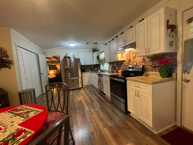 a kitchen that has a lot of cabinets a sink and appliances