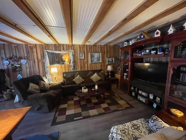 a living room with furniture a flat screen tv and a chandelier