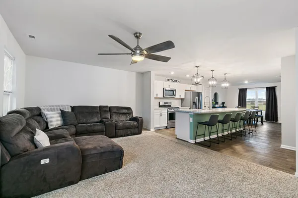 a living room with furniture and kitchen view