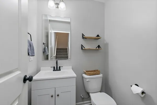 a bathroom with a toilet sink and mirror
