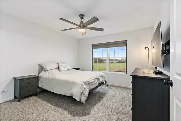 a bedroom with a bed table and window