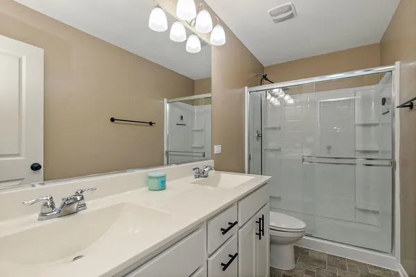 a bathroom with a sink a toilet and shower