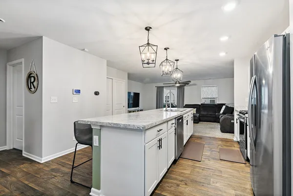a kitchen with stainless steel appliances granite countertop a sink stove and refrigerator