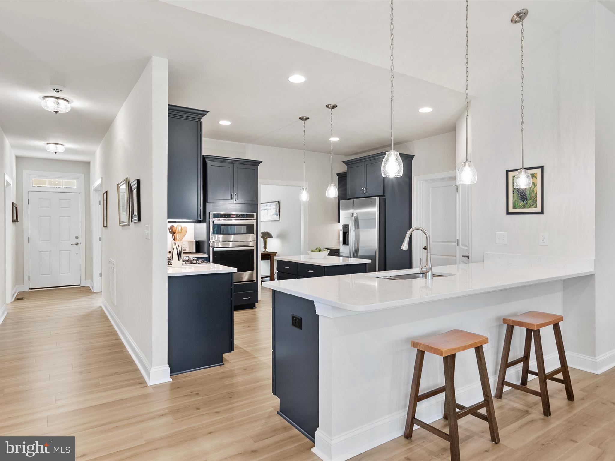 22657 Deep Woods Road Milton, DE 19968 - Photo 5 of 51 a kitchen with stainless steel appliances kitchen island a refrigerator and a sink