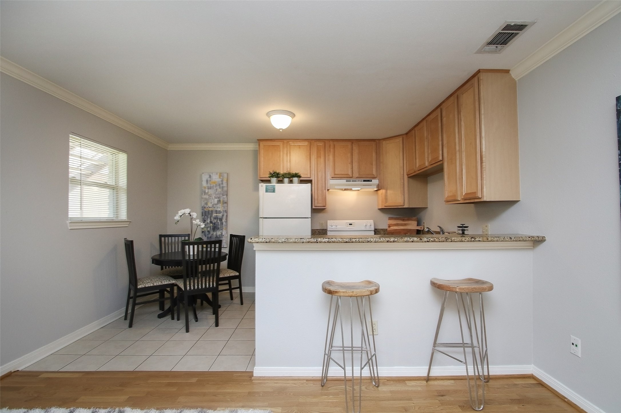 1307 Welch Street, Unit 6 Houston, TX 77006 - Photo 10 of 23 a kitchen with a table chairs refrigerator and cabinets
