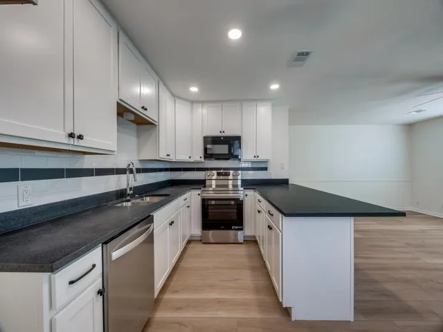 a kitchen with stainless steel appliances granite countertop a sink and stove top oven
