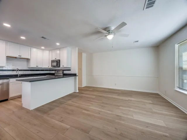 a view of kitchen with refrigerator and window