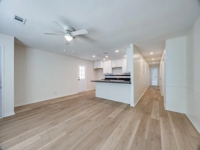 a view of kitchen with kitchen island wooden floor and ceiling fan