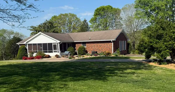 a front view of a house with a yard and trees