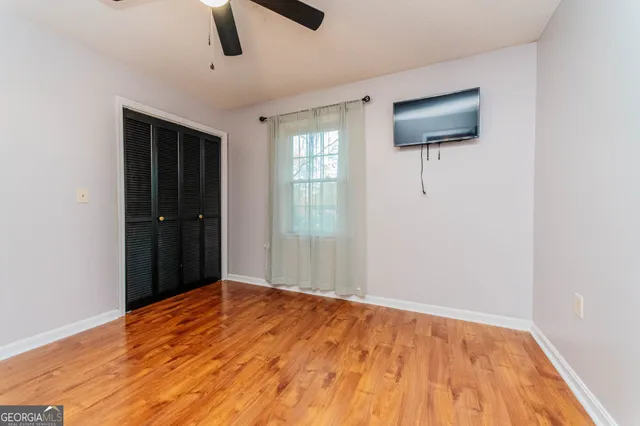 a view of empty room with window and ceiling fan