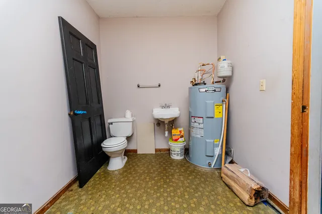 a bathroom with a granite countertop toilet and a sink