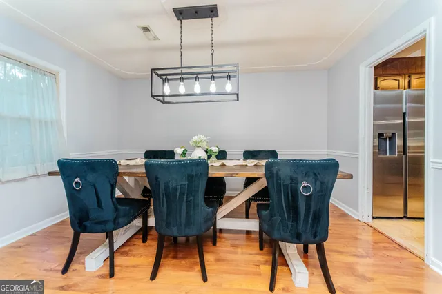 a view of a dining room with furniture wooden floor and a chandelier
