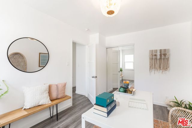 a living room with furniture a mirror and a potted plant