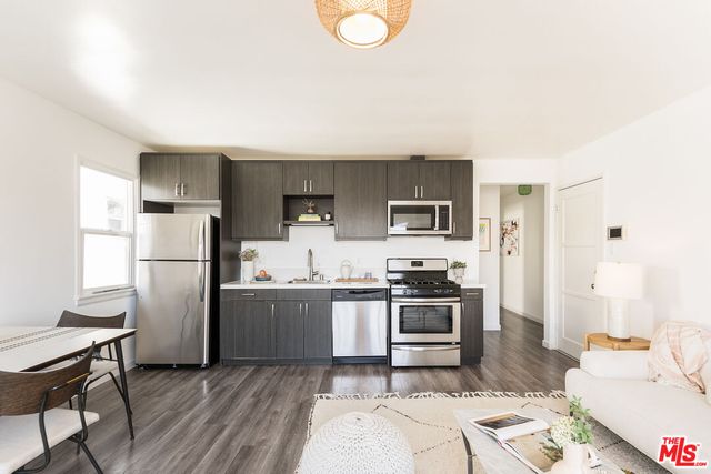a kitchen with stainless steel appliances granite countertop a refrigerator stove top oven and sink