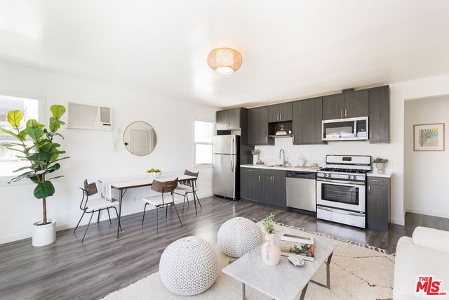 a living room with furniture kitchen view and a potted plant