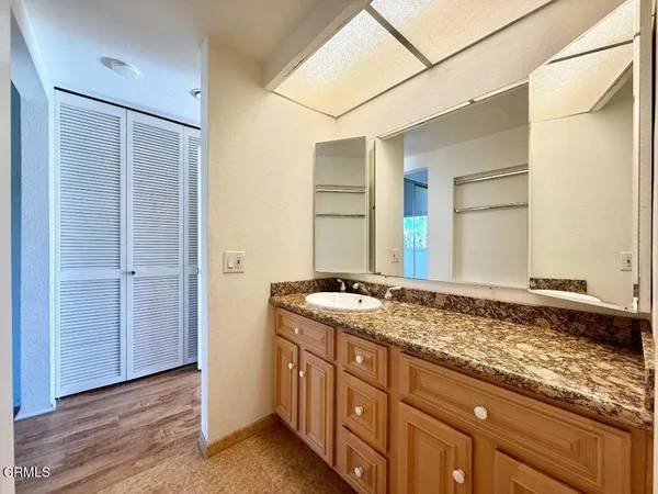 a bathroom with a granite countertop sink and a mirror