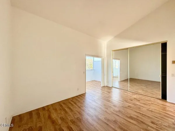 a view of an empty room with wooden floor