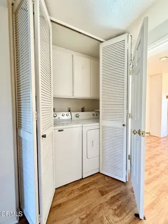 a view of a kitchen with white cabinets and wooden floor