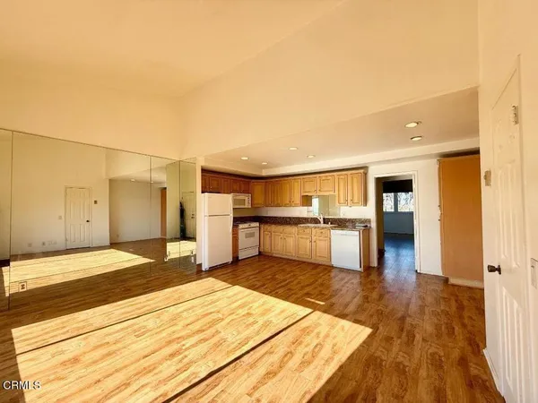 a view of a kitchen with wooden floor and a kitchen