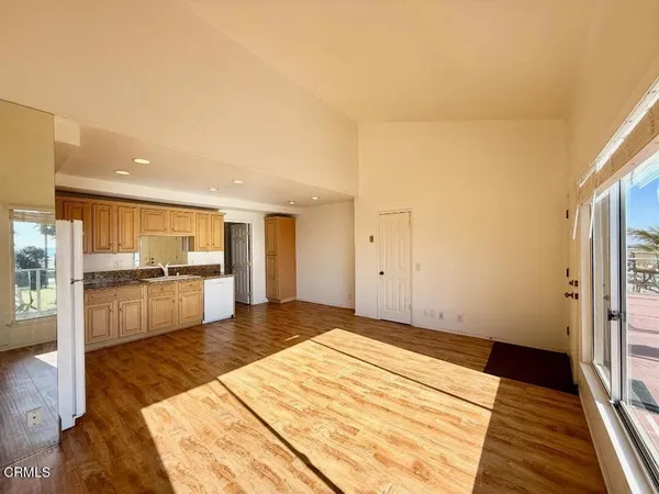 a large bedroom with a bed and a view of kitchen