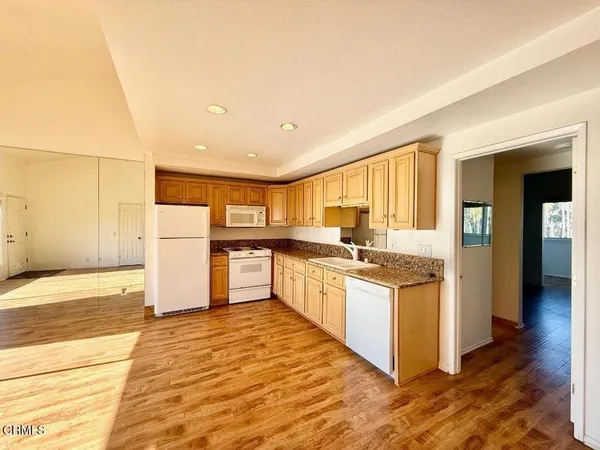 a kitchen with stainless steel appliances granite countertop a refrigerator and a stove top oven
