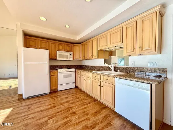 a kitchen with stainless steel appliances granite countertop a stove a sink dishwasher and a refrigerator
