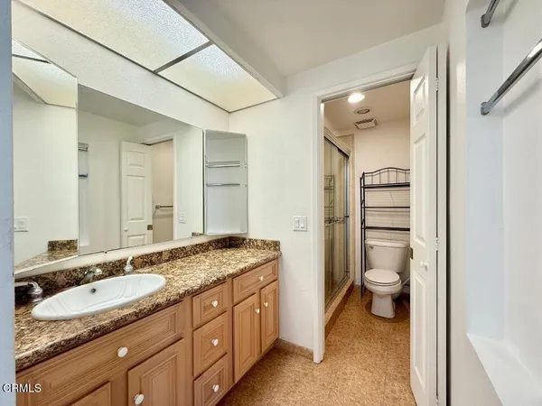 a bathroom with a granite countertop sink toilet and shower