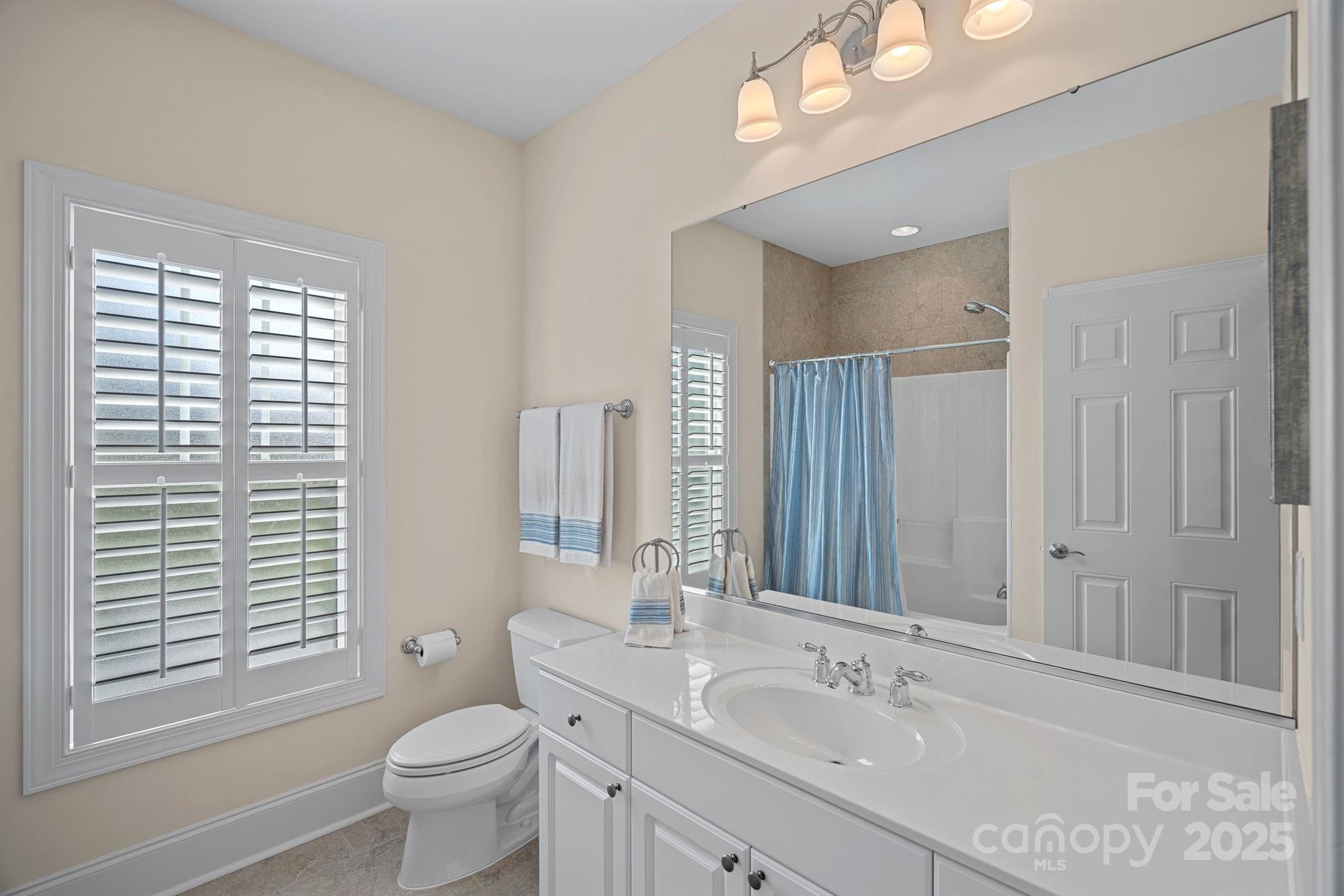 9803 Tree Canopy Road Charlotte, NC 28277 - Photo 26 of 42 a bathroom with a granite countertop sink toilet and large mirror