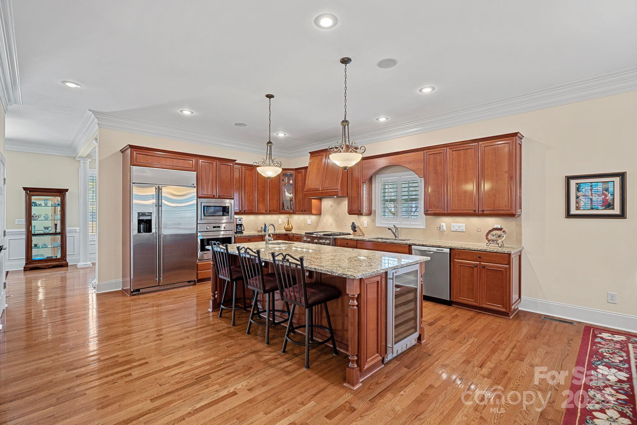 9803 Tree Canopy Road Charlotte, NC 28277 - Photo 5 of 42 a large kitchen with a large center island and stainless steel appliances