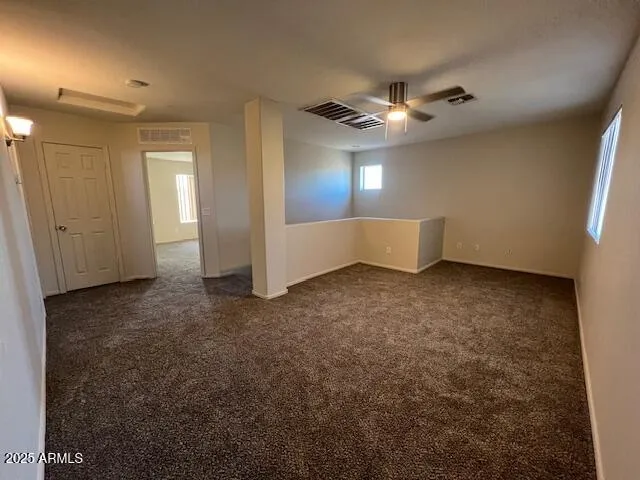 en empty room with windows and fan