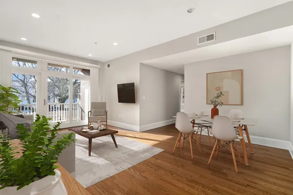 a living room with furniture and a flat screen tv with wooden floor