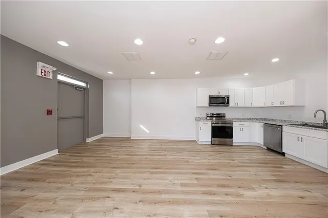 a large kitchen with kitchen island a sink stainless steel appliances and cabinets