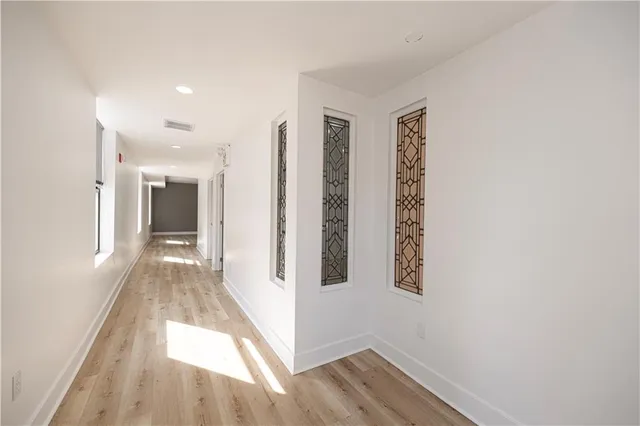 a view of a hallway with wooden floor and staircase