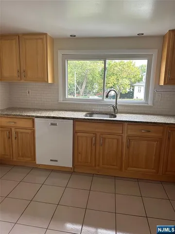 a kitchen with a sink window and cabinets