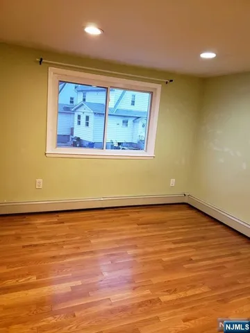a view of a room with wooden floor and window