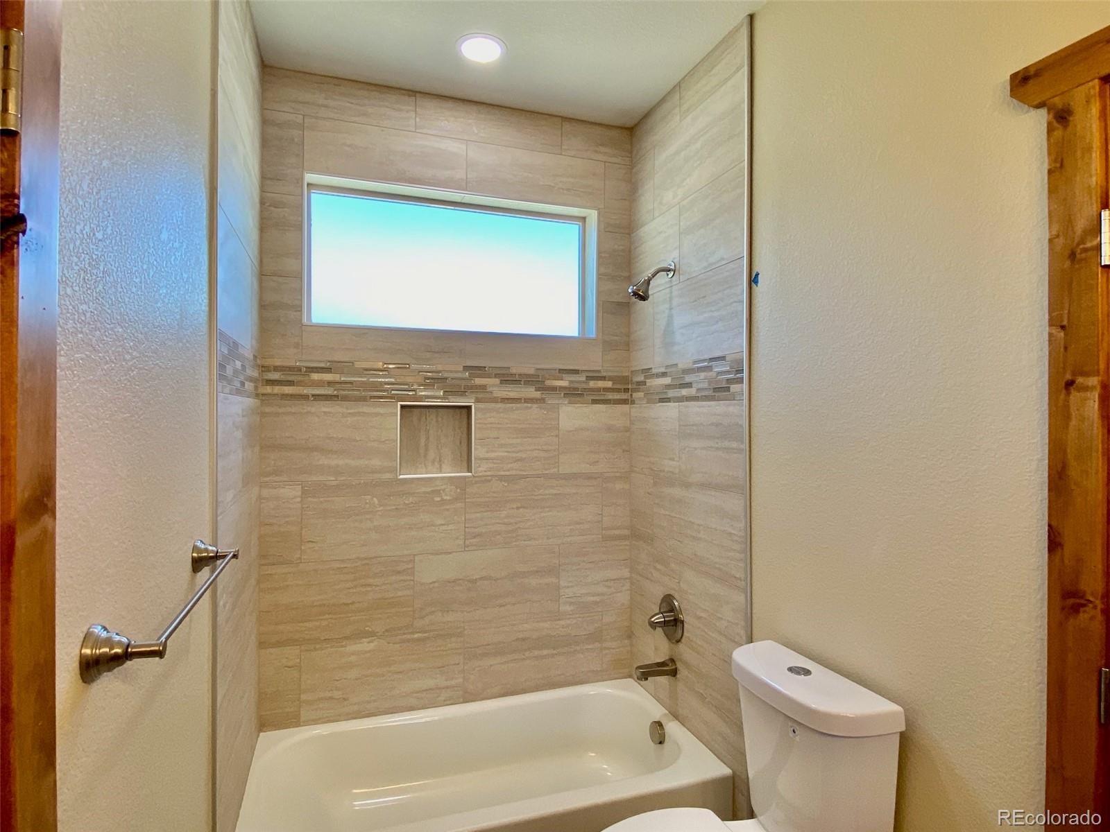 174 Chickadee Lane Bailey, CO 80421 - Photo 17 of 39 a bathroom with a granite countertop toilet a sink and bathtub