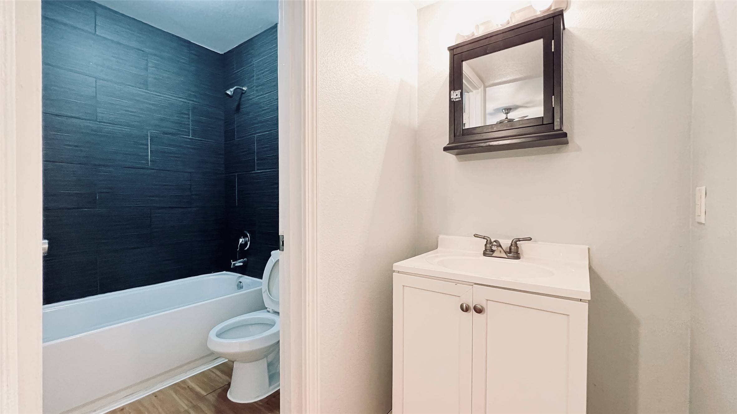 2301 Ohlen Road, Unit 209 Austin, TX 78757 - Photo 7 of 10 A well-appointed bathroom with a sleek vanity and a tiled shower-tub combination.